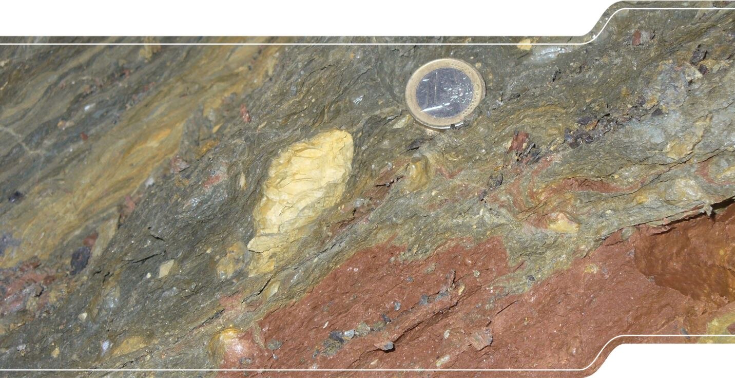 Das Bild zeigt einen gestörten Tonstein mit gelben Geröllen aus dolomitischem Kalkstein.