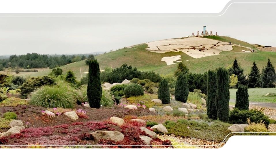 Das Bild zeigt den Berg im Findlingspark Nochten, an dessen Hang die Geografie Skandinaviens im Kleinformat mittels Kies für Festland und Gras für Meer nachgebildet ist.