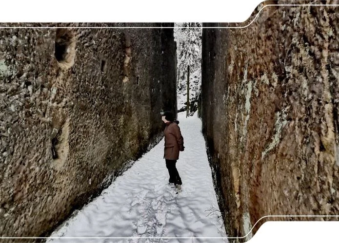 Das Bild zeigt einen schmalen Durchgang durch den Felsen zum Steinbruch Schwarzes Loch.