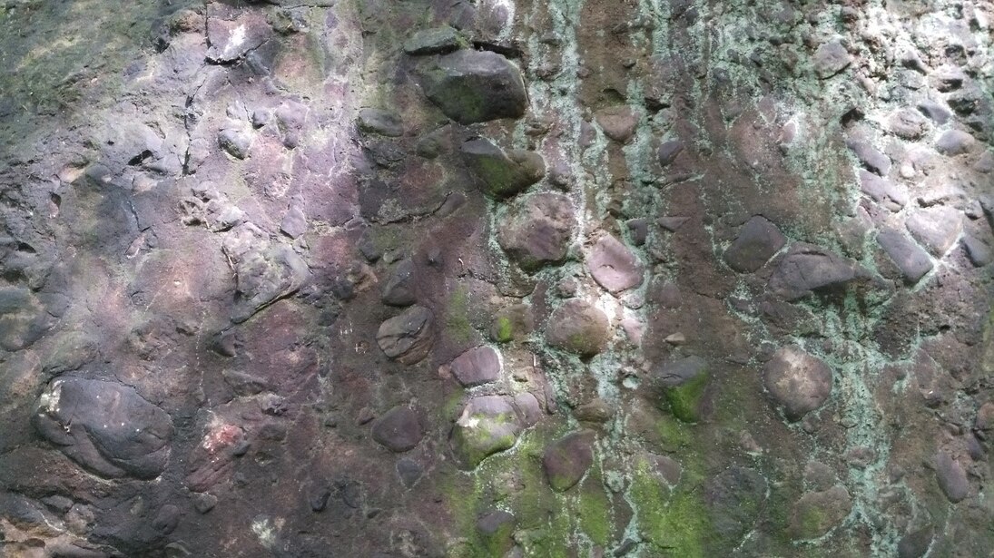 Felswand mit Konglomeratgeröllen