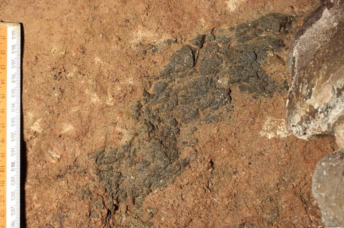 Rötlichbrauner Tuff mit dunklem Basaltschlackeneinschluss aus dem Rest eines Basaltschlackenwalls in Stolpen.
