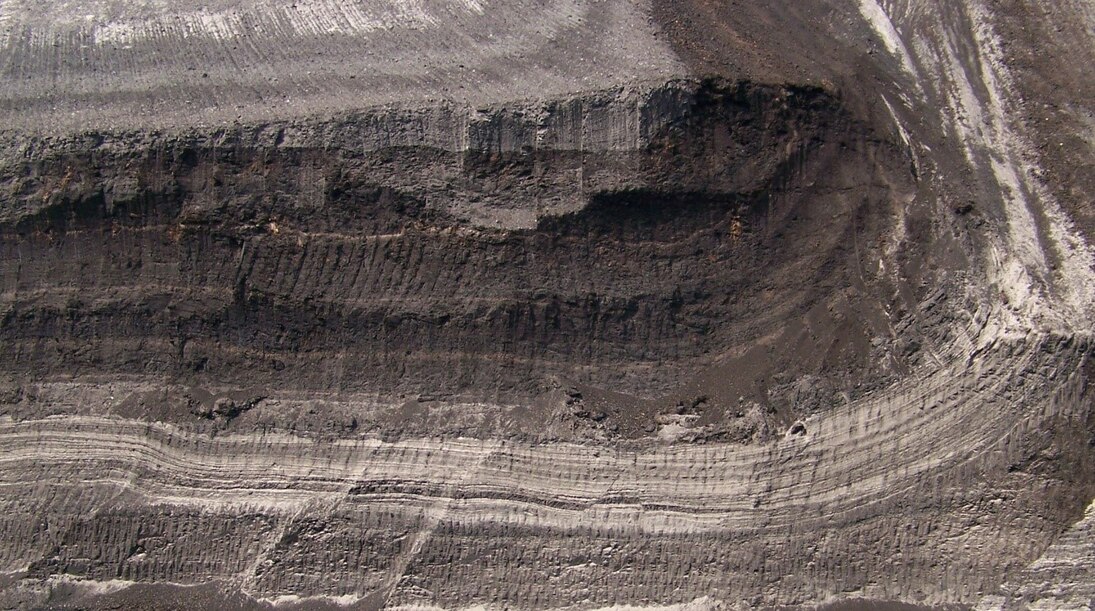 Die während des Pleistozäns vorrückenden Gletscher übten einen gewaltigen Druck auf den Untergrund aus. Dieser führte unter anderem zur Faltung der tertiären Sedimente. Rechts in der Abbildung ist die beginnende Faltung eines Braunkohlenflözes erkennbar.