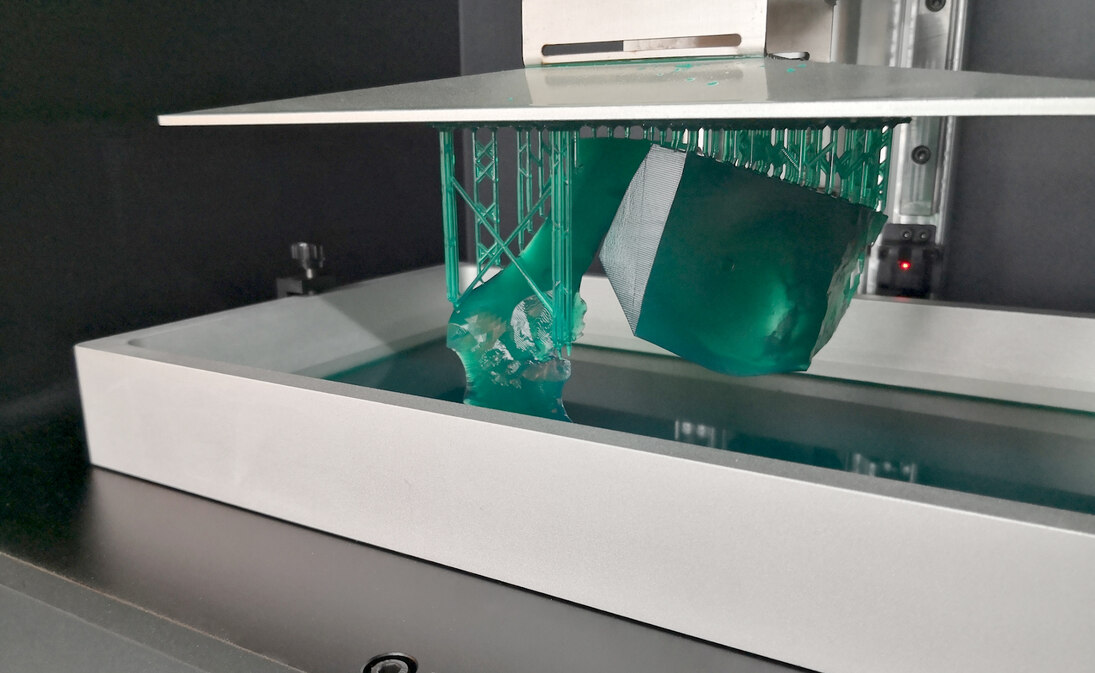 3D-Druck im SLA-Verfahren; Modellteile werden nach oben aus dem Kunstharzbad gezogen.