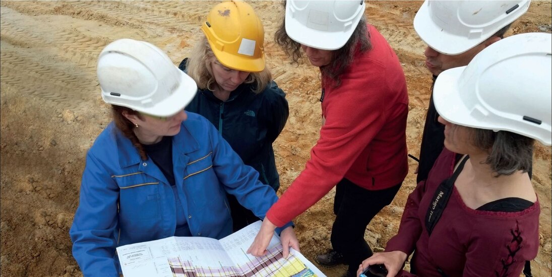 Das Bild zeigt Geologen bei der Diskussion eines geologischen Profilschnittes.